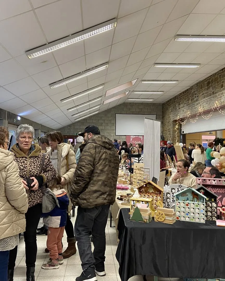 La salle paroissiale pleine de visiteurs entre les stands, marché de Noël 2025
