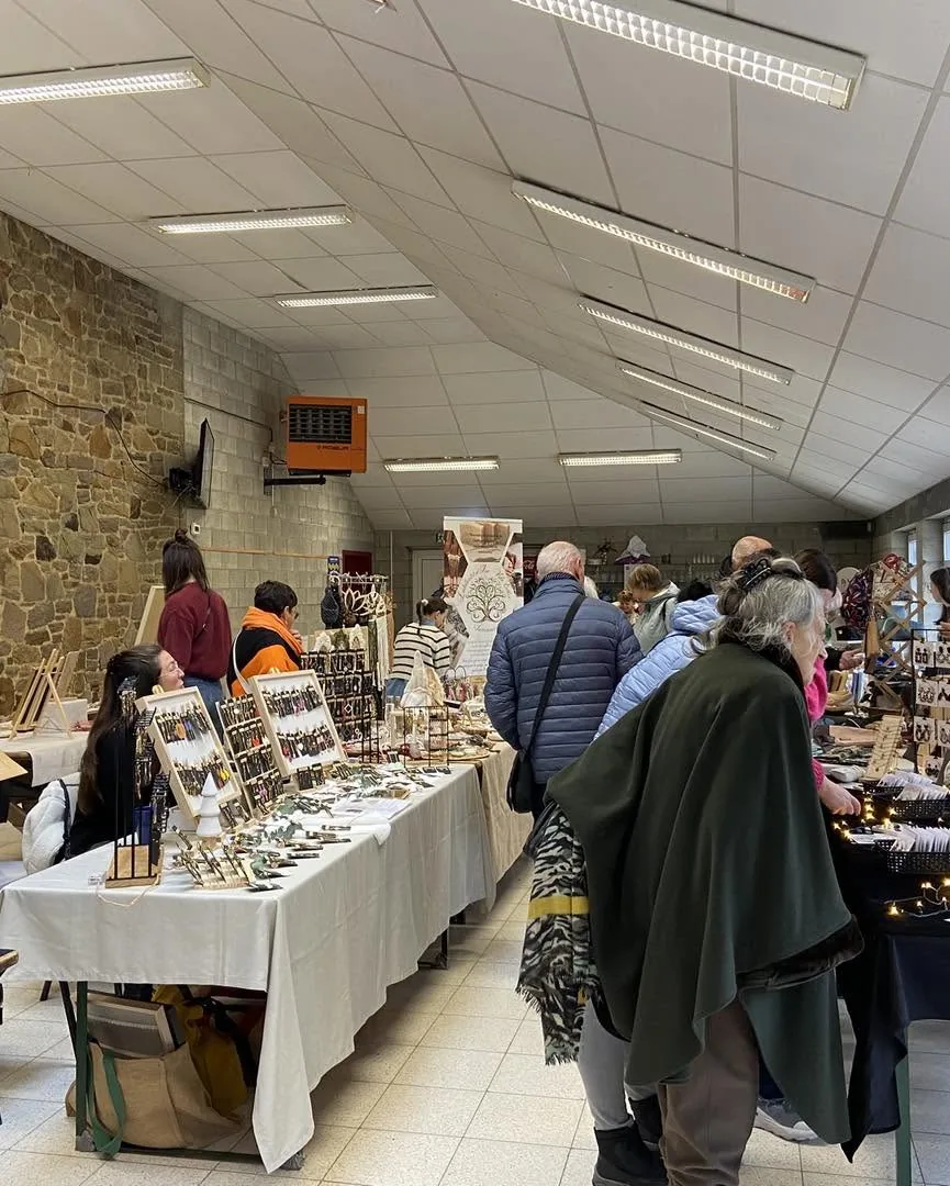 Les tables d'artisans alignées dans la salle, avec des bijoux et des décorations