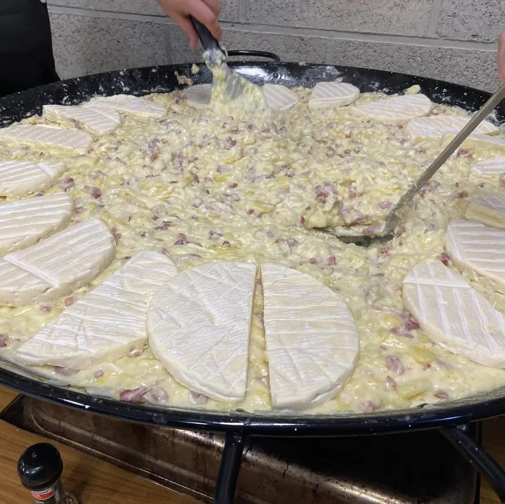 Une grande poêle de tartiflette avec les reblochons qui fondent