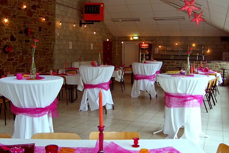La salle dressée pour une fête, tables nappées de blanc